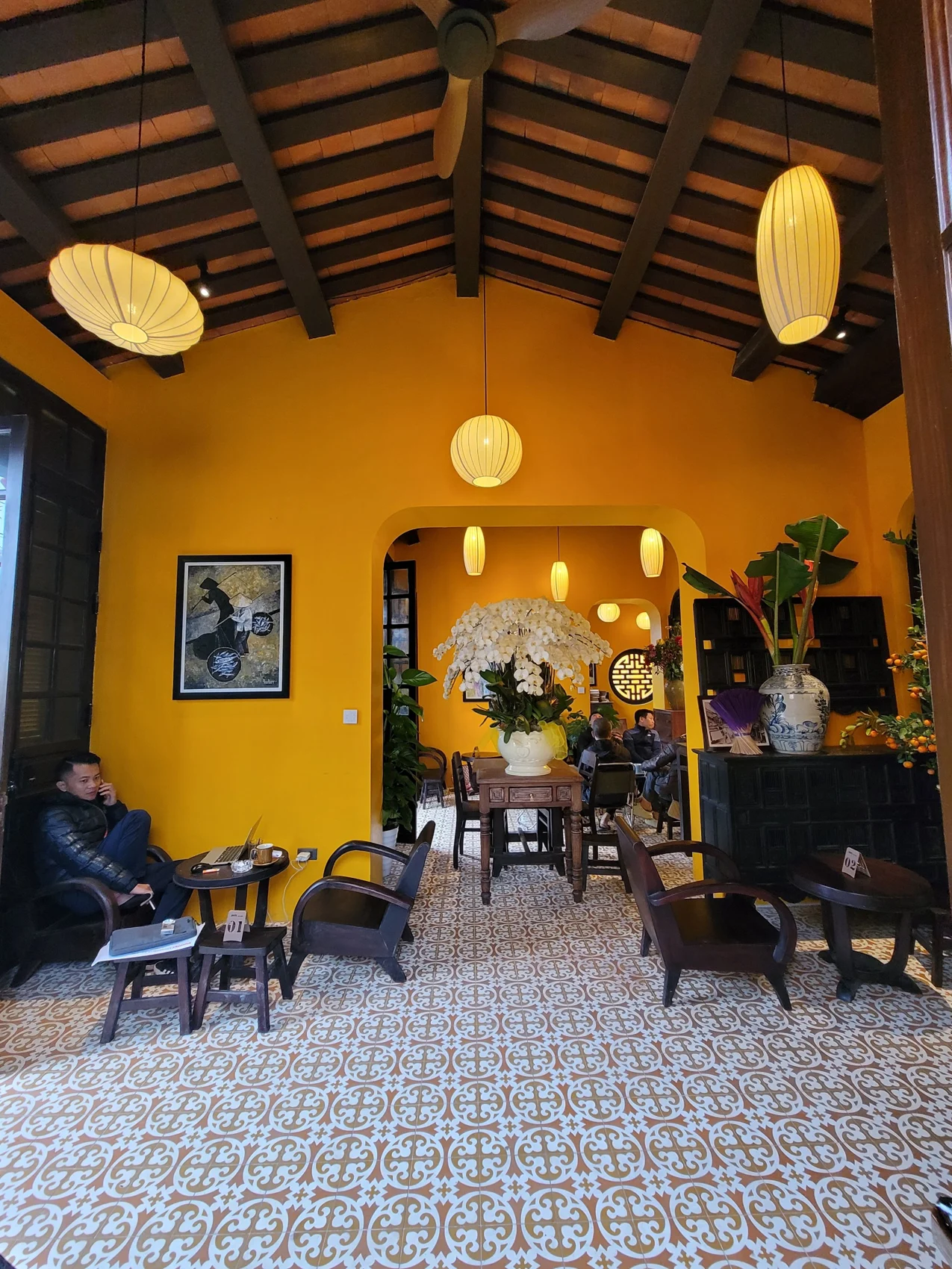 Toàn cảnh phòng với mái gỗ, nền lát và khách