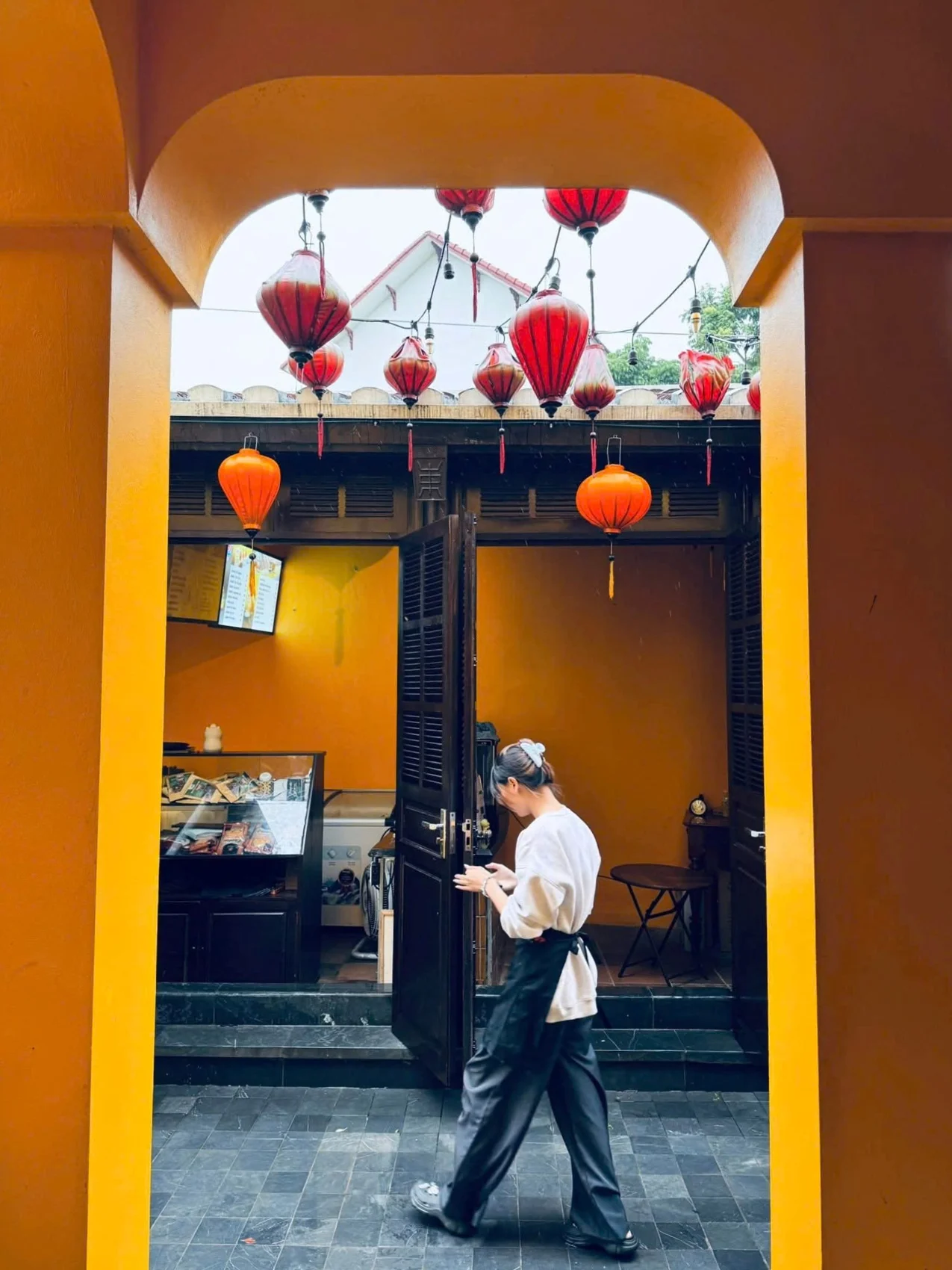 Người đi qua khung vòm giữa các khối nhà